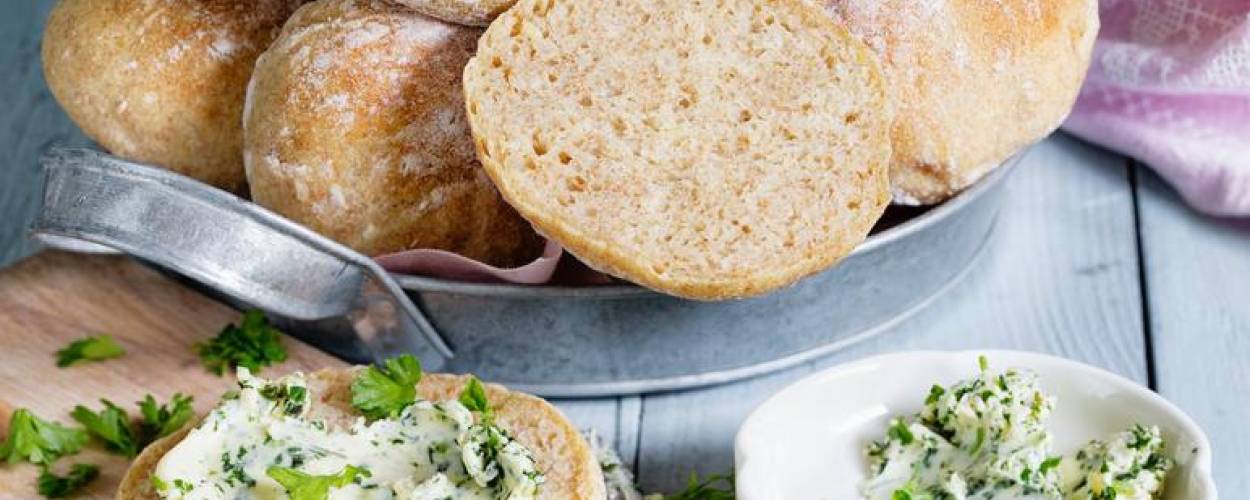 Brötchen in Korb und aufgeschnitten mit Frischkäse