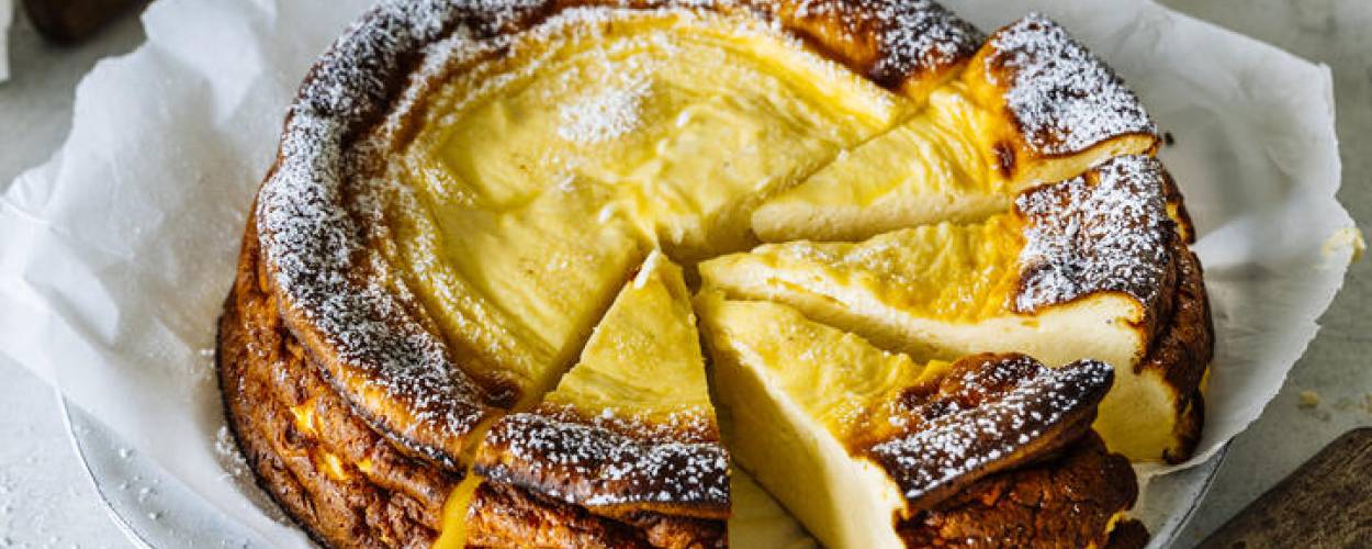 Käsekuchen mit Puderzucker auf weißem Teller