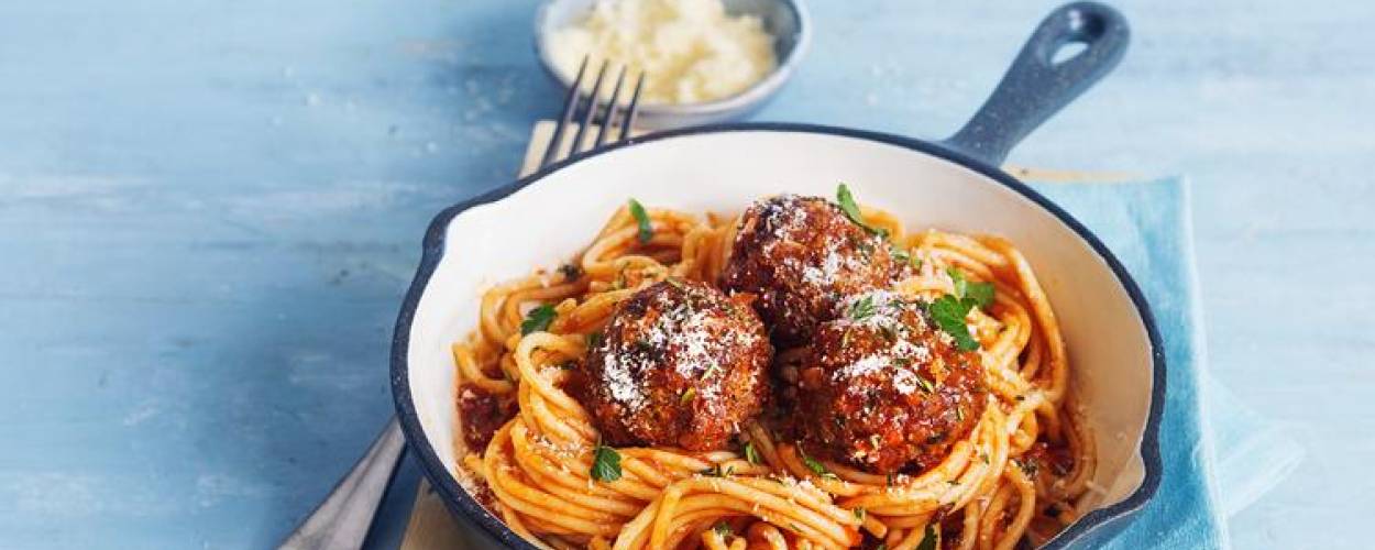 Spaghetti mit saftigen Fleischbällchen in blauer Pfanne