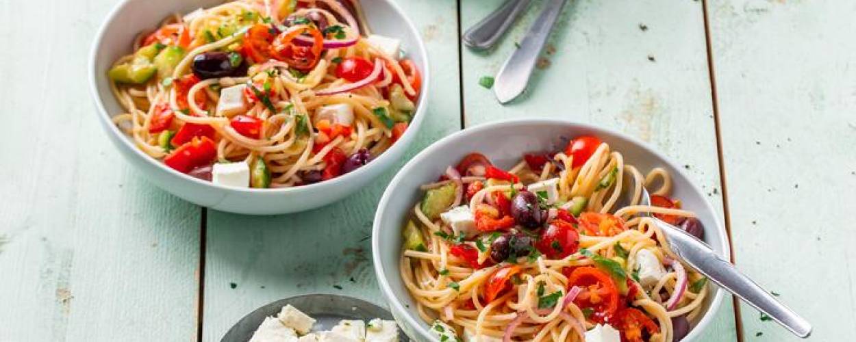 Spaghetti mit Gemüse, Kräutern und Feta in Schüsseln
