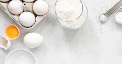 Backzutaten in Behältern, die auf einer Arbeitsfläche verteilt sind, flat lay