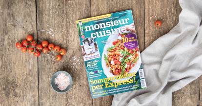 Die Sommerausgabe von monsieur cuisine liegt frisch gedruckt auf einem rustikalen Holztisch