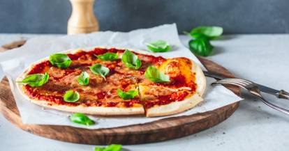 Pizza Margherita auf einem Holzbrett angerichtet