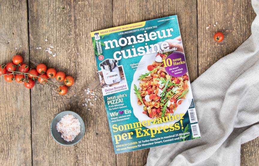 Die Sommerausgabe von monsieur cuisine liegt frisch gedruckt auf einem rustikalen Holztisch