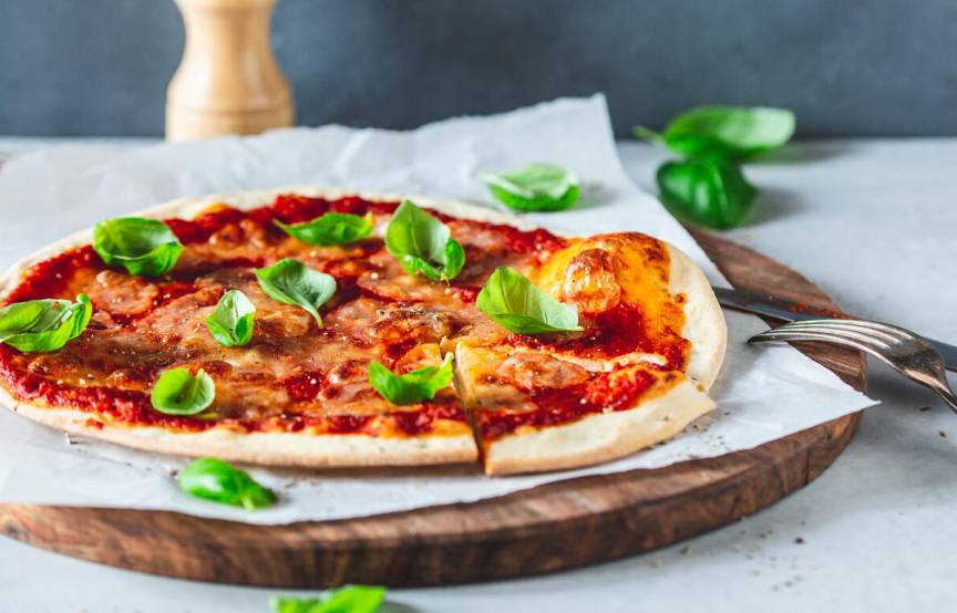 Pizza Margherita auf einem Holzbrett angerichtet