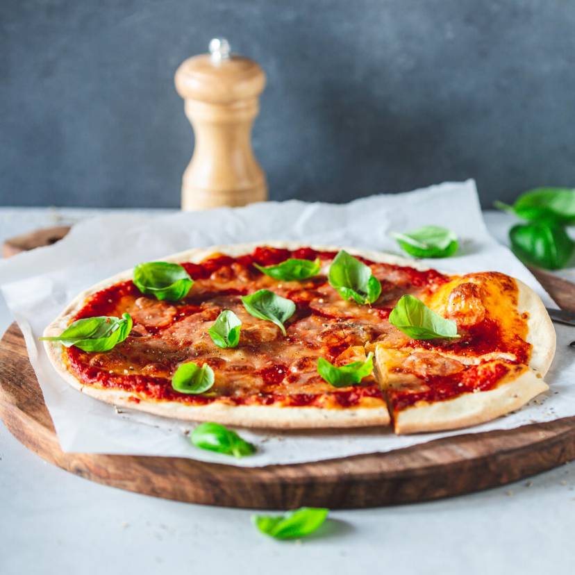 Pizza Margherita auf einem Holzbrett angerichtet