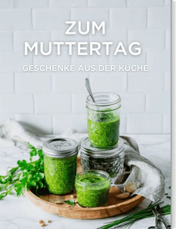 Grünes Pesto in drei Gläsern mit Petersilie und Schnittlauch auf Holzbrett