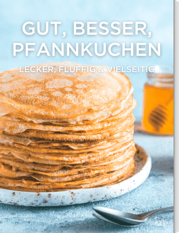 Pfannkuchen gestapelt auf weißem Teller mit Honig im Glas
